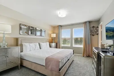 a bedroom with a large bed and a television at Ev3115 - Sunset Bay Villa in Kissimmee
