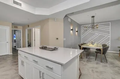 a kitchen with a white counter top and a table at Ev101 - The Luxe Loft in Kissimmee