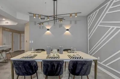 a dining room with a table with blue chairs at Ev101 - The Luxe Loft in Kissimmee