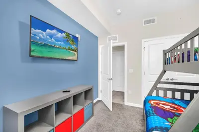 a bedroom with blue walls and a bunk bed and a ladder at Ev3180 Unit203 - Captains Cove Villa in Kissimmee