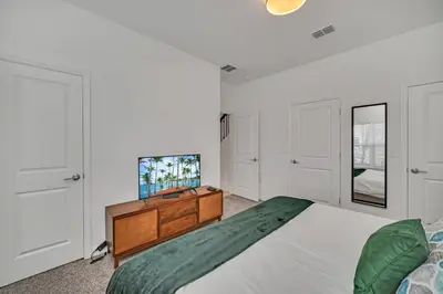 a bedroom with a bed and a dresser and a tv at Ev4228 - Storey Retreat in Kissimmee