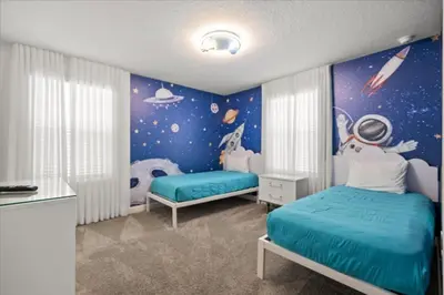 a bedroom with two beds and a space themed wall at 4324Prolouge in Kissimmee
