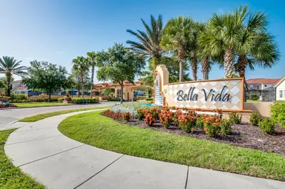 a sign at the entrance to a villa village with palm trees at Ev4550 - Bella Vista Haven in Kissimmee