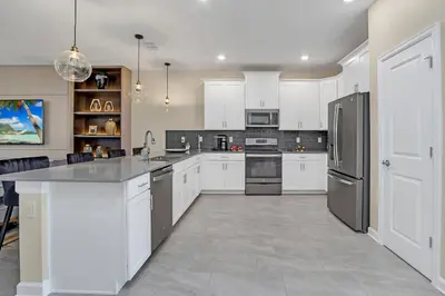 a kitchen with white cabinets and stainless steel appliances at Ev4568 - Storey Oasis in Kissimmee