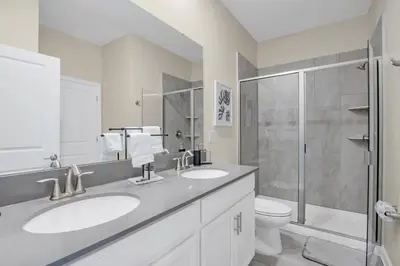 a white bathroom with two sinks and a shower at Ev4568 - Storey Oasis in Kissimmee