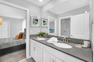 a bathroom with two sinks and a large mirror at Ev4569 - Storey Lake Serenity in Kissimmee