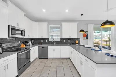 a large white kitchen with white cabinets and appliances at Ev4569 - Storey Lake Serenity in Kissimmee