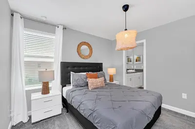 a bedroom with a large bed and a mirror at Ev4569 - Storey Lake Serenity in Kissimmee