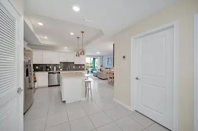 a kitchen with white cabinets and a white door at Ev208 - The Storey Condo in Kissimmee