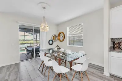 a dining room with a glass table and white chairs at Ev4795 - Kings Oasis in Kissimmee