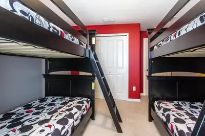 two bunk beds in a room with a red wall at Ev4796 - Palm Bay Retreat in Kissimmee