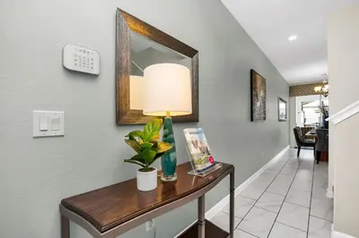 a hallway with a table with a lamp and a mirror at Ev4804 - Starlight Retreat in Kissimmee