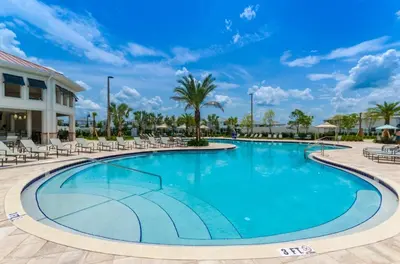a swimming pool at a resort with chairs and palm trees at 4811Ll Amazing 5 Bedroom 4 Bathroom in Kissimmee