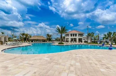 a swimming pool at a resort with palm trees and a building at 4811Ll Amazing 5 Bedroom 4 Bathroom in Kissimmee