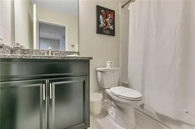 a bathroom with a toilet and a sink and a mirror at Ev4815 - Regal Escape Villa in Kissimmee