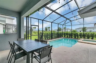 a dining room with a table and a swimming pool at Ev4815 - Regal Escape Villa in Kissimmee