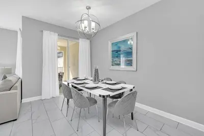 a white dining room with a table and chairs at Ev4876 - Charming Palms Villa in Kissimmee