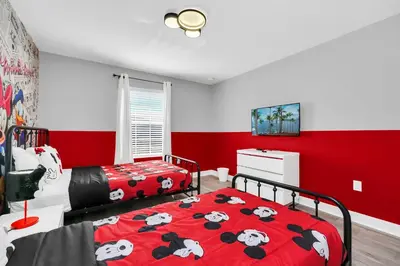 a bedroom with two beds and a red wall at Ev4876 - Charming Palms Villa in Kissimmee