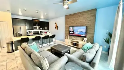 a living room with a couch and a kitchen at Ev4835 - Adventure Cove Villa in Kissimmee