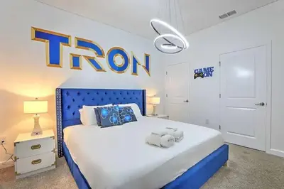 a bedroom with a blue bed with a iron sign on the wall at Ev4835 - Adventure Cove Villa in Kissimmee