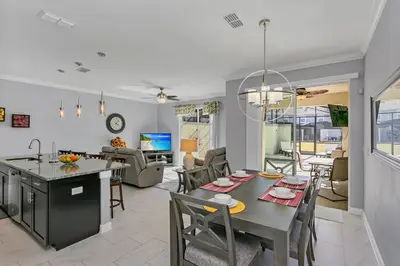 a kitchen and living room with a table and chairs at Ev4886 - Palm Haven Escape in Kissimmee