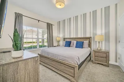 a bedroom with a bed and a large window at Ev4987 - Raceway Retreat in Kissimmee
