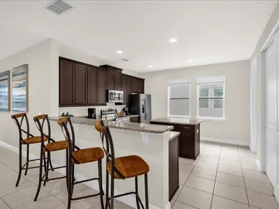 a kitchen with a counter and four chairs in it at Ev7501 - Encore in Orlando