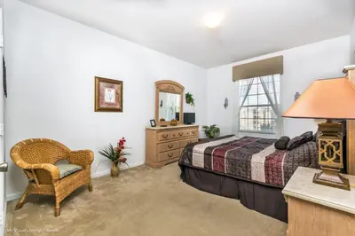 a bedroom with a bed and a dresser and a mirror at Ev76604 - Windsor Condo in Orlando