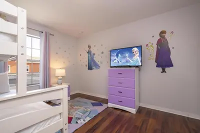a bedroom with a dresser with a tv on the wall at Ev89270 - Paradise Manor in Kissimmee