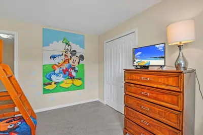 a bedroom with a bed and a tv and a dresser at Ev8950 - Paradise Oasis Villa in Kissimmee