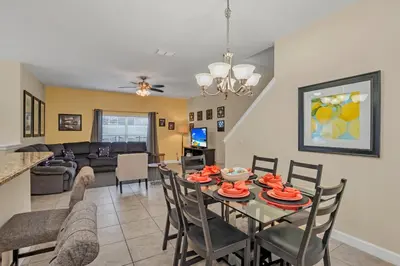 a dining room and living room with a table and chairs at Ev8950 - Paradise Oasis Villa in Kissimmee