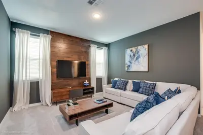 a living room with a white couch and a flat screen tv at Ev9071- Solara Cove in Orlando