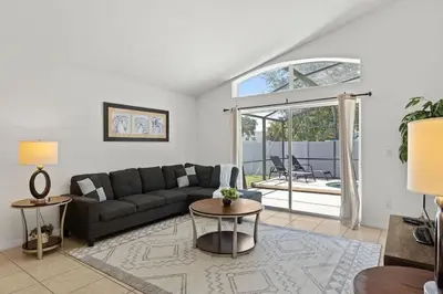 a living room with a couch and a table at Casa 4Q c/ Piscina & Spa no Veranda Palms in Kissimmee