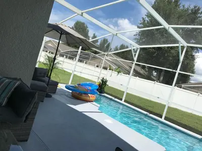 a swimming pool in front of a building at Beautiful 5BR home near Disney with private pool, large yard & BBQ in Orlando