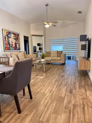 a living room with a couch and a table at Beautiful 5BR home near Disney with private pool, large yard & BBQ in Orlando