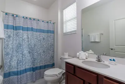 a bathroom with a toilet and a sink and a shower at BellaVida 8 bed Theme Rooms in Kissimmee
