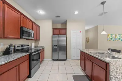 a kitchen with a stainless steel refrigerator and counters at 4 Bed Close to Disney Private Pool in Kissimmee