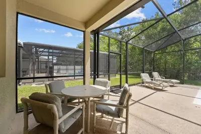a glass house with a table and chairs on a patio at 4 Bed Close to Disney Private Pool in Kissimmee