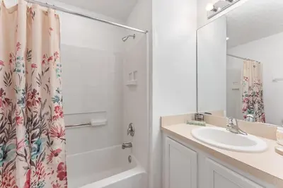 a bathroom with a sink and a shower curtain at Casa Térrea 4Q c/ Piscina e Game Room in Kissimmee