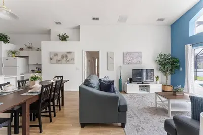 a living room and dining room with a couch and a table at Casa Térrea 4Q c/ Piscina e Game Room in Kissimmee