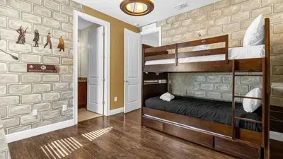 a bedroom with bunk beds in a brick wall at Vila 7Q Temática c/ Piscina – 6mi Disney in Orlando