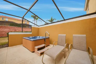 a balcony with a hot tub and two chairs at NEW Cozy 2 Bedrooms2Baths At Encantada in Kissimmee