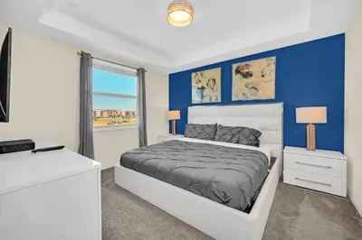a bedroom with a white bed and blue walls at Ev4721C304 - Sunset Nest in Kissimmee