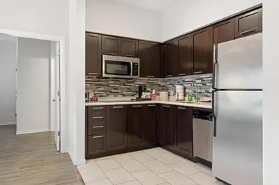 a kitchen with wooden cabinets and a stainless steel refrigerator at Orlando Getaway with Pool View Balcony in Orlando