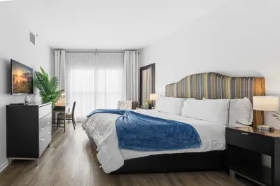 a bedroom with a large bed and a desk and chair at Orlando Getaway with Pool View Balcony in Orlando
