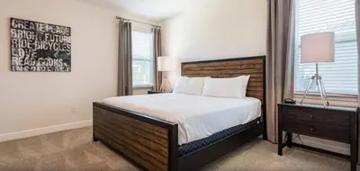 a bedroom with a large bed and a nightstand and a bed sidx sidx sidx at Ultimate Mansion-9Bed-PoolSpaGame in Orlando