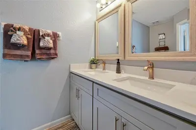 a bathroom with a sink and a mirror and towels at Windsor Hills Marvel Themed Home with Private Pool in Orlando