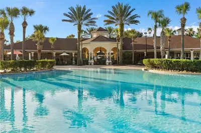 a large swimming pool in front of a house with palm trees at Windsor Hills Marvel Themed Home with Private Pool in Orlando