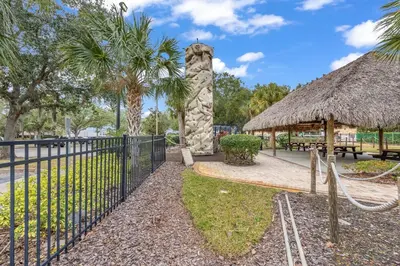a gate with a fence and a thatch roof at Family Resort Condo Disney 5 miles in Kissimmee