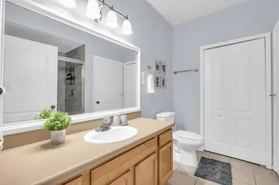 a bathroom with a sink and a toilet and a mirror at Family Resort Condo Disney 5 miles in Kissimmee